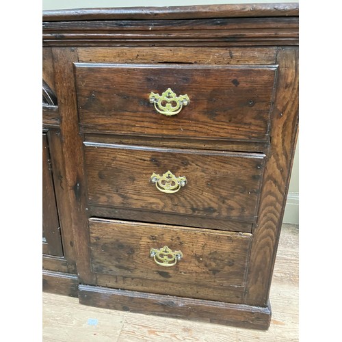 458 - A oak dresser base having an inverted breakfront arched door cupboard inlaid with star paterae to th... 