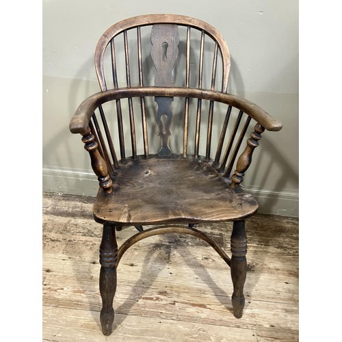 469 - A 19th century elm and ash low back Windsor armchair, turned legs joined by a crinoline stretcher