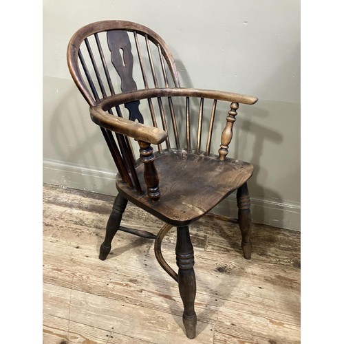 469 - A 19th century elm and ash low back Windsor armchair, turned legs joined by a crinoline stretcher