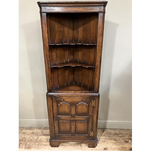 471 - An oak standing corner cupboard having a moulded cornice above two open shaped shelves, the lower se... 