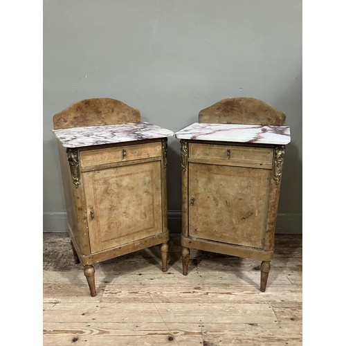 472 - A pair of late 19th century figured walnut and gilt metal mounted bedside cabinets with marble tops ... 