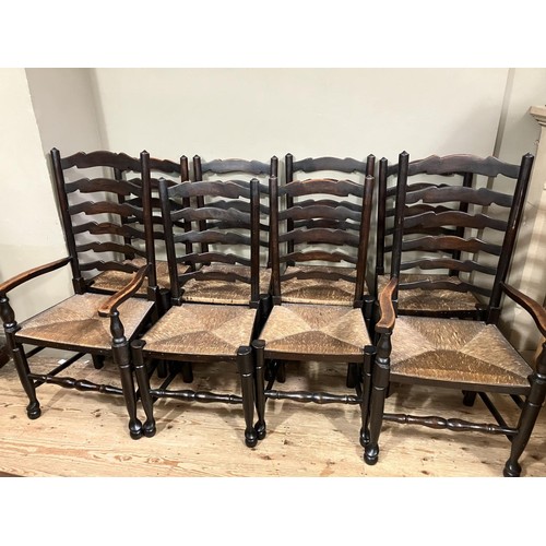 493 - A set of eight early 20th century ladder back and rush seated dining chairs comprising two carvers a... 