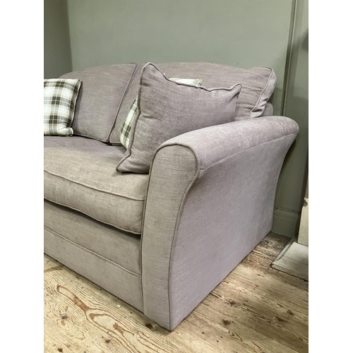 515 - A two seater sofa upholstered in mushroom linen with loose cushions