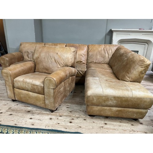 516 - An 'L' shaped corner sofa in tan leather with matching reclining armchair, purchased from Barker and... 