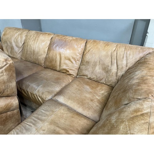 516 - An 'L' shaped corner sofa in tan leather with matching reclining armchair, purchased from Barker and... 