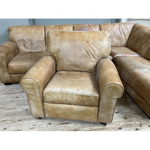 516 - An 'L' shaped corner sofa in tan leather with matching reclining armchair, purchased from Barker and... 