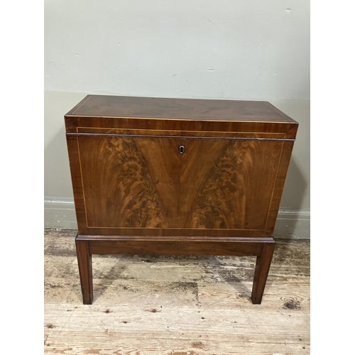 517 - An early 20th century figured mahogany cellarette, rectangular and having a lift up top, fitted for ... 