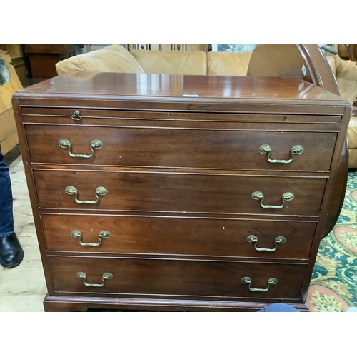 503 - A mahogany bachelor's chest having a pull slide, four graduated drawers with swing handles, bracket ... 