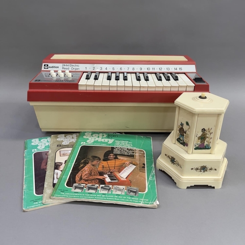 96 - A Winfield 2444 Electric Reed Organ and three Winfield music books, along with a Selcol musical ciga... 