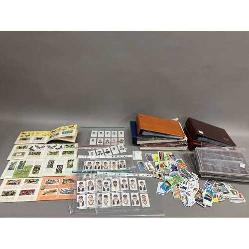 69 - Five cigarette card albums and a quantity of sleeves (empty), four trade card albums and a small num... 