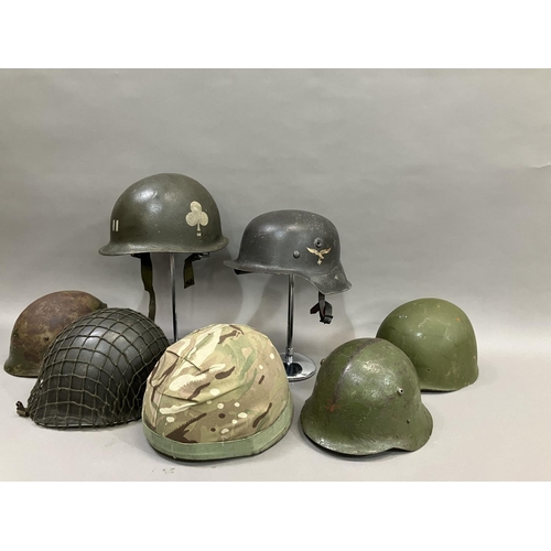 26 - A group of six WWII and later steel helmets including a Belgian example; USA, and a reproduction Luf... 