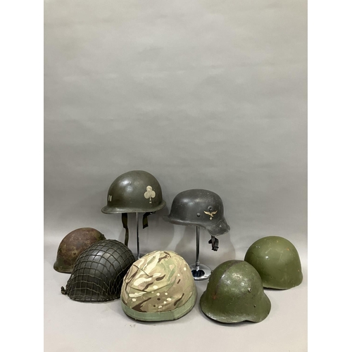 26 - A group of six WWII and later steel helmets including a Belgian example; USA, and a reproduction Luf... 