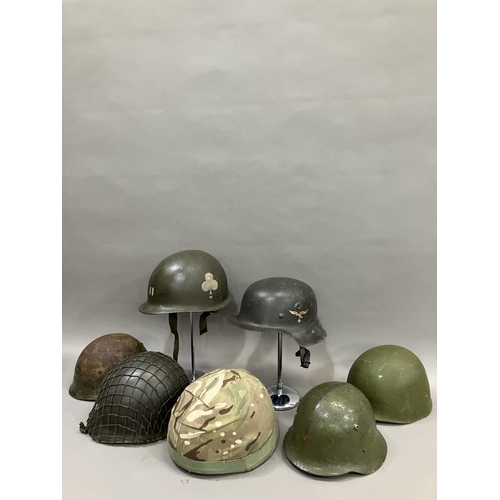 26 - A group of six WWII and later steel helmets including a Belgian example; USA, and a reproduction Luf... 