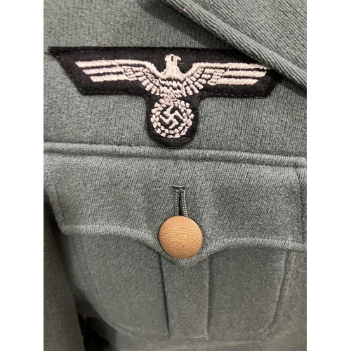 23 - A German post war jacket with a reproduction WWII Wermachtsadler eagle, together with a black field ... 