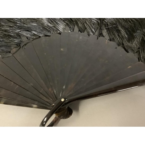 84 - A good black late 19th century ostrich feather fan, the monture of tortoiseshell, with good mottling... 