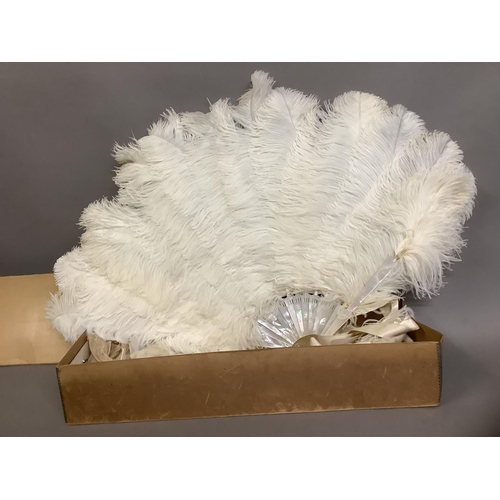 89 - A large and fluffy white ostrich feather fan, the monture of white mother of pearl, fitted with a wi... 