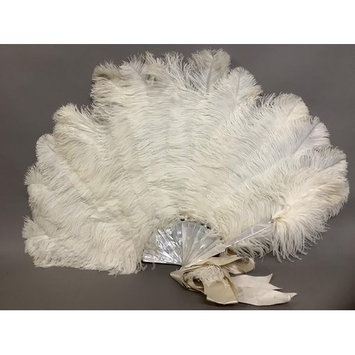 89 - A large and fluffy white ostrich feather fan, the monture of white mother of pearl, fitted with a wi... 