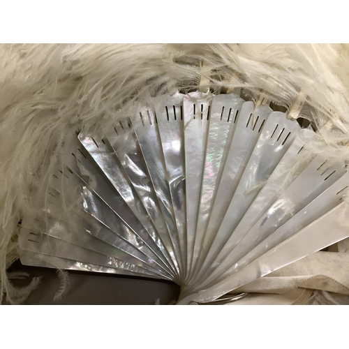 89 - A large and fluffy white ostrich feather fan, the monture of white mother of pearl, fitted with a wi... 