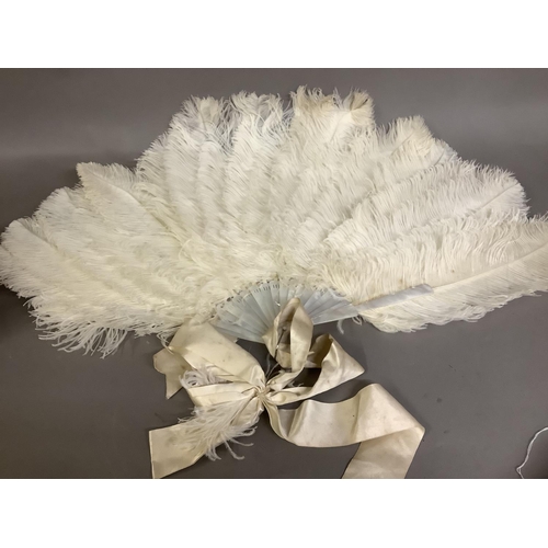 89 - A large and fluffy white ostrich feather fan, the monture of white mother of pearl, fitted with a wi... 