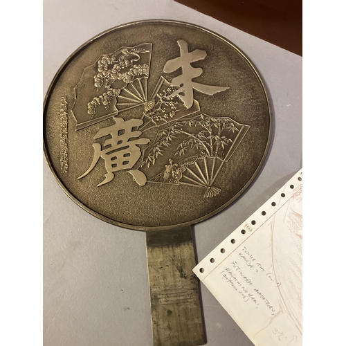 124 - A Japanese Meiji period gilt bronze hand mirror, kagami,  the recto with a design of fans, and calli... 