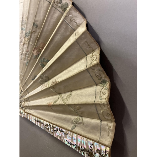 128 - A large fan, the monture of pink mother of pearl, gilded, the cream silk leaf Chinese, being embroid... 