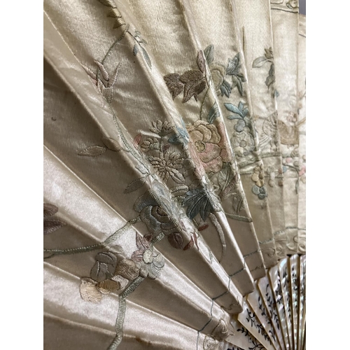 128 - A large fan, the monture of pink mother of pearl, gilded, the cream silk leaf Chinese, being embroid... 