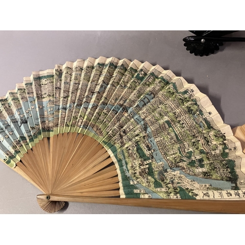 133 - Oriental fans: A detailed Chinese folding fan with double paper leaf, each side showing a topographi... 