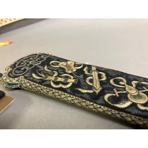 136 - A 19th century Chinese fan case or sleeve, navy blue silk embroidered with auspicious symbols, edged... 