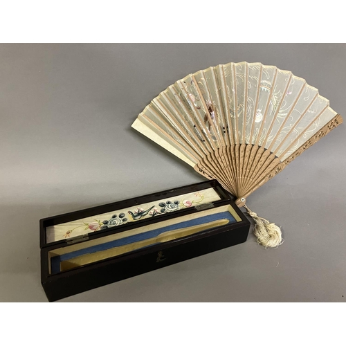 137 - A Chinese gauze fan, Ming Dynasty, the wood monture carved, the leaf embroidered in pastel silks wit... 