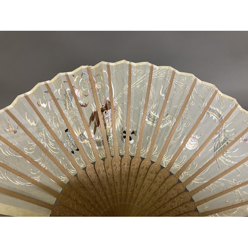 137 - A Chinese gauze fan, Ming Dynasty, the wood monture carved, the leaf embroidered in pastel silks wit... 