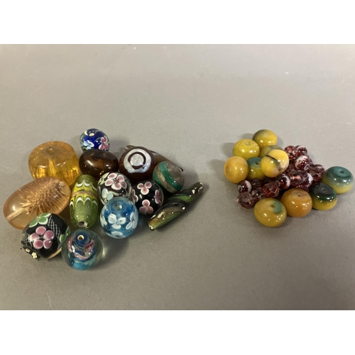 197 - Trade beads: a selection of glass beads, many with floral patterns, to include 10 in a deep yellow, ... 