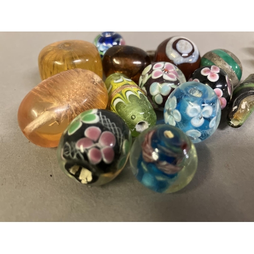 197 - Trade beads: a selection of glass beads, many with floral patterns, to include 10 in a deep yellow, ... 