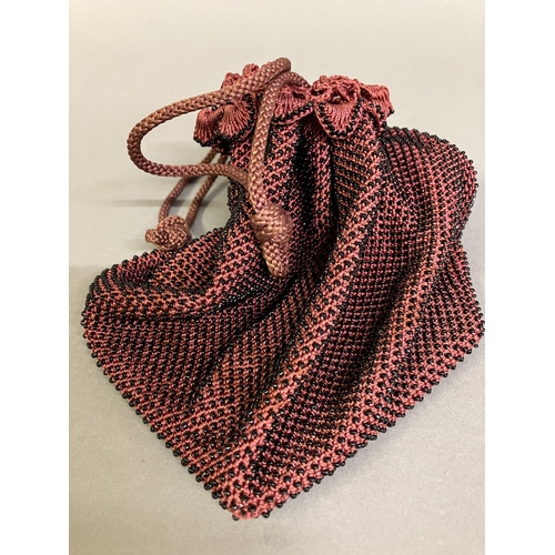 254 - A cerise beaded bag with drawstring; together with a woven beaded bag with drawstring, in pink, whit... 