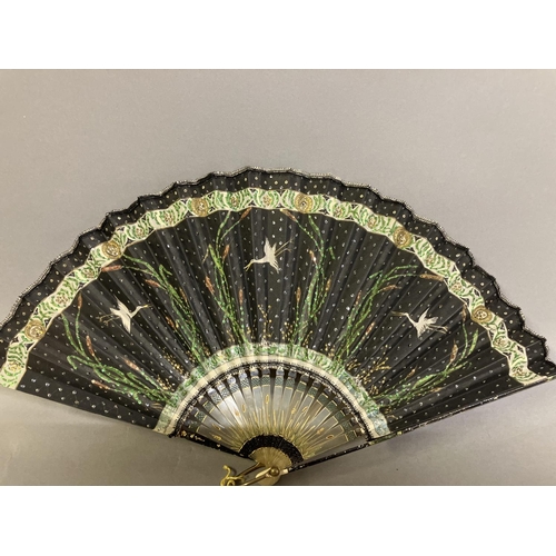 37 - An Art Nouveau fan, the monture of bone, shaped and gilded, the silk leaf painted with a lady in a s... 