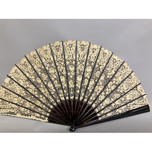 52 - A large late 19th century Carrickmacross lace fan, worked with more detail towards the upper edge, w... 