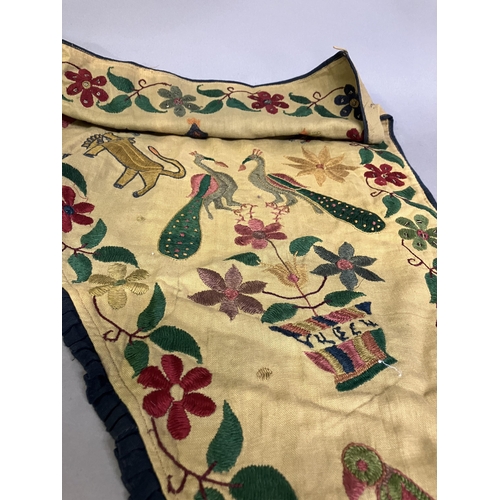 183 - World Textiles: A shaped linen door hanging, Toran, Indian, embroidered in coloured silks with flowe... 