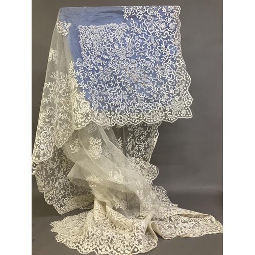 265 - A large embroidered net Edwardian wedding veil, the design creating deep borders and worked well int... 