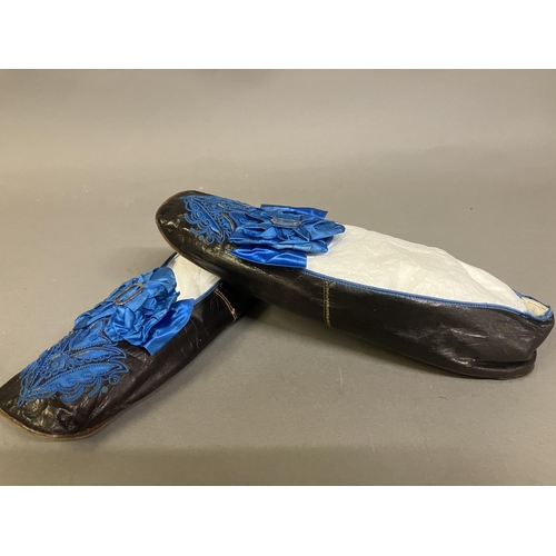 302 - A fine pair of French mid-19th century slippers, black glacé kid, edged with blue braid, square toes... 