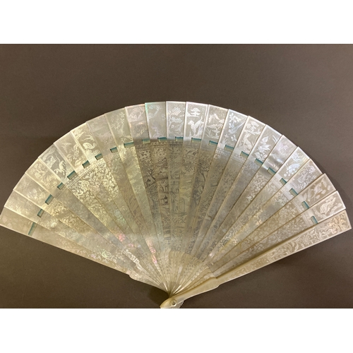 140B - A Chinese Mother of pearl brisé fan, with 21 inner sticks and two guards, entirely etched with tiny ... 