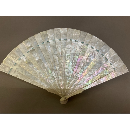 140B - A Chinese Mother of pearl brisé fan, with 21 inner sticks and two guards, entirely etched with tiny ... 