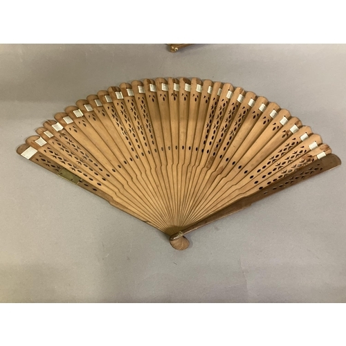 4 - Two late 18th century wood fans, the first a brisé with rounded tips, pierced, with applied cartouch... 