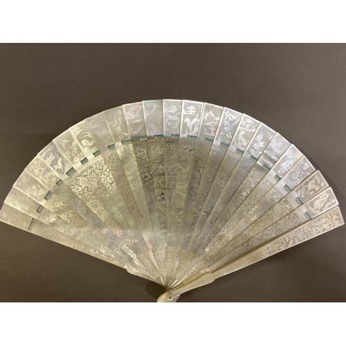 140B - A Chinese Mother of pearl brisé fan, with 21 inner sticks and two guards, entirely etched with tiny ... 