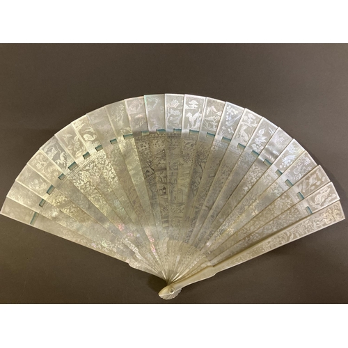 140B - A Chinese Mother of pearl brisé fan, with 21 inner sticks and two guards, entirely etched with tiny ... 