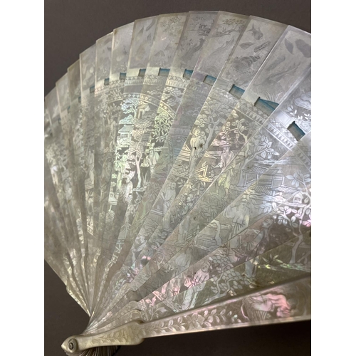 140B - A Chinese Mother of pearl brisé fan, with 21 inner sticks and two guards, entirely etched with tiny ... 