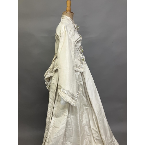 334 - A mid-1860’s two-piece wedding ensemble, cream silk, the tailored bodice with bell sleeves, the slee... 