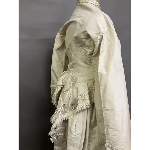 334 - A mid-1860’s two-piece wedding ensemble, cream silk, the tailored bodice with bell sleeves, the slee... 