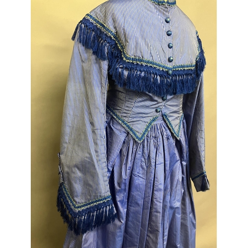 337 - C 1865, a striped blue silk two-piece ensemble, short bodice with rear detail, trimmed with fringing... 