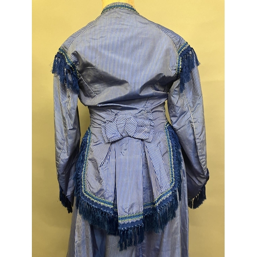 337 - C 1865, a striped blue silk two-piece ensemble, short bodice with rear detail, trimmed with fringing... 