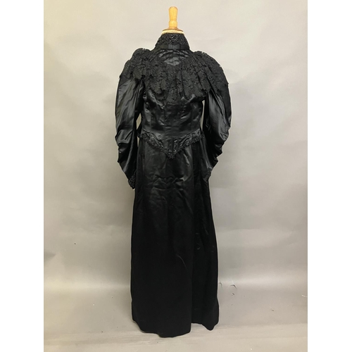 340 - C 1895/1900, a two piece black silk satin skirt and boned bodice bearing the attribution, in gold on... 