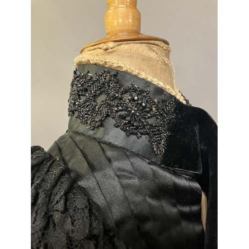 340 - C 1895/1900, a two piece black silk satin skirt and boned bodice bearing the attribution, in gold on... 